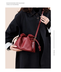 Détail du sac seau bordeaux à cordon avec texture cuir et logo minimaliste