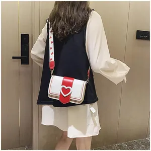 Détail du sac à bandoulière cœur rouge et blanc avec large sangle réglable