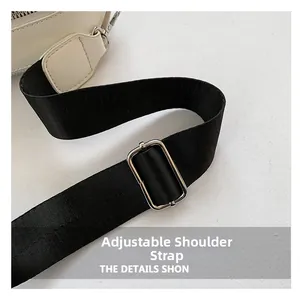Detail of adjustable black nylon shoulder strap with silver buckle on the square bag