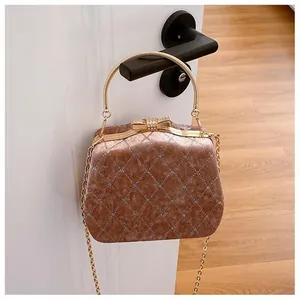 Détail du sac boîte en velours avec texture matelassée et fermoir nœud en diamant