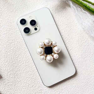 Detailed close-up of luxury phone grip with inlaid pearls and sparkling rhinestones