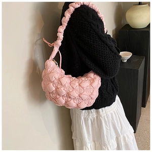 Detailed side view of pink quilted cloud bag with matching ruffled shoulder strap