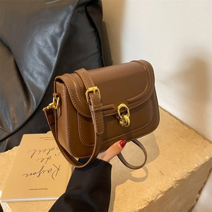 Brown leather crossbody bag with vintage gold chain buckle and adjustable shoulder strap