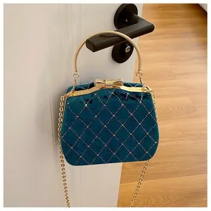 Détail du sac de soirée en velours bleu foncé avec motif matelassé et cristaux brillants