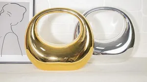 Detail view of modern round ceramic vases with gold and silver electroplated mirror finish