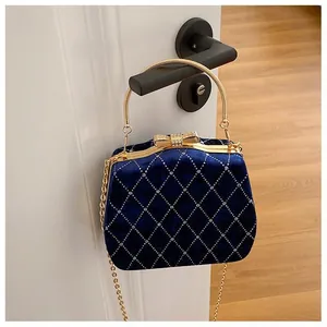Détail du sac de soirée en velours bleu avec losanges en strass et fermoir nœud