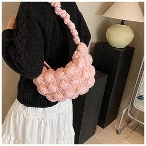 Detailed back view of a pink quilted heart pattern underarm bag with ruffled strap