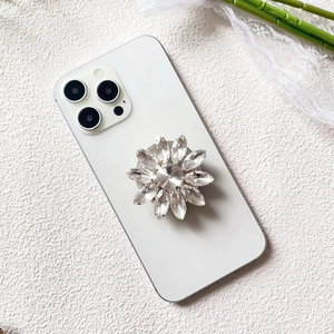 Detailed close-up of a luxury sunflower crystal phone socket on a white smartphone