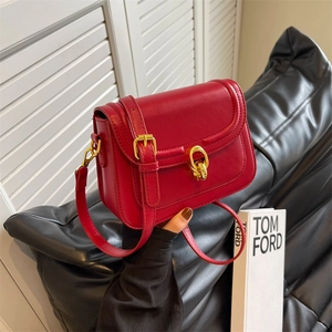 Minimalist red leather crossbody bag with elegant gold ring clasp and slim strap