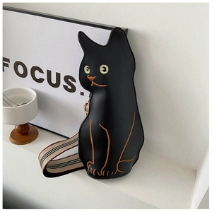 Close-up of black cat shaped shoulder bag with embroidery and woven strap details