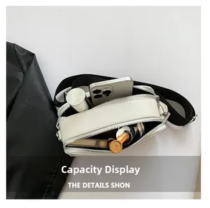 Internal view of a white leather crossbody bag showing spacious double zip compartments