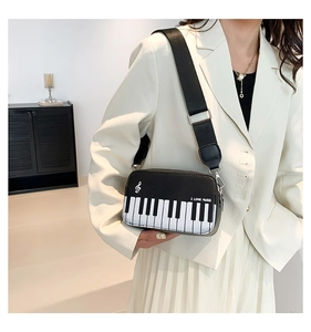 Detail showing music theme embroidery and piano key design on a stylish crossbody bag