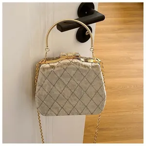 Détail du sac boîte en velours avec motif matelassé et fermoir nœud en cristal sur l'anse