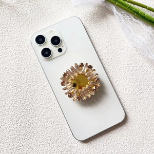 Detailed view of luxury sunflower phone grip with champagne crystals and gold mirror finish