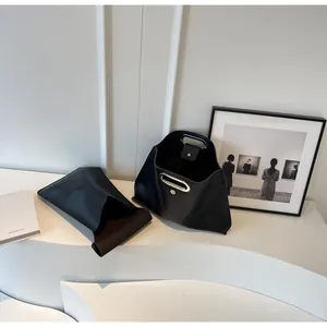 Detailed shot of a black geometric tote bag featuring its unique silver metal hollow handle