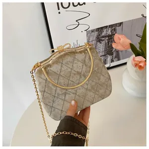 Détail d'une pochette de soirée en velours champagne avec fermoir nœud orné de strass