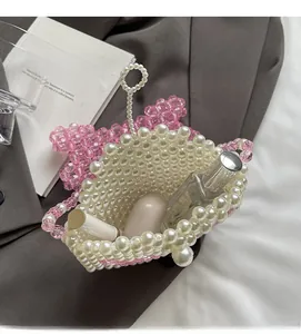 Detailed view showing storage capacity for lipstick and perfume in a beaded skull bag