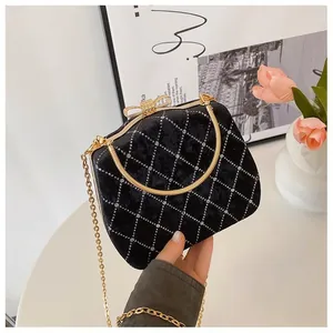 Détail du sac boîte en velours avec motif en losange et fermoir nœud en cristal