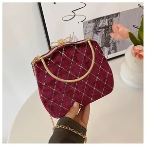 Détail de la pochette en velours bordeaux avec motif losanges et fermoir noeud doré