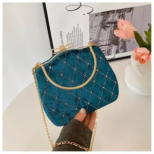 Détail du sac de soirée en velours sarcelle avec treillis en strass et fermoir nœud doré