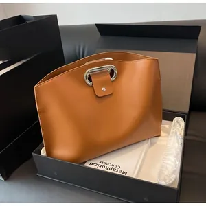 Brown leather tote with silver ring handle displayed with premium gift box and dust bag