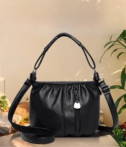 Detail showing the pleated faux leather texture and silver hardware of the black crossbody bag