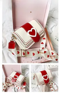Détail du sac bandoulière cœur avec large sangle décorative dans son coffret cadeau