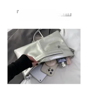 Silver metallic clutch bag interior showing storage space for tablet and makeup