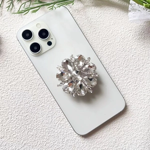 Macro shot of luxury crystal flower phone grip on white smartphone with aesthetic background