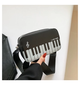 Detailed shot of mini piano themed crossbody bag with musical note embroidery and keys