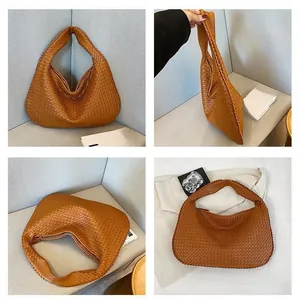 Dettagli macro della borsa hobo in pelle intrecciata caramello con manico e zip di chiusura