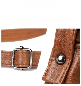 Detail of premium caramel brown textured leather with golden buckle and rivet hardware
