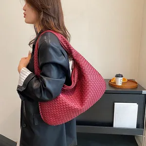 Dettaglio macro della borsa hobo in pelle intrecciata rossa con trama artigianale Intrecciato