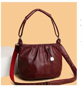 Macro shot of dark red pleated leather texture and vertical zipper detail on handbag