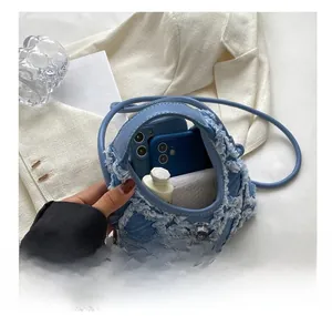 Detail view of denim handbag interior capacity showing space for two smartphones