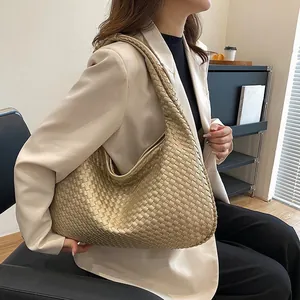 Dettaglio della trama in pelle intrecciata oro champagne e curva a mezzaluna della borsa
