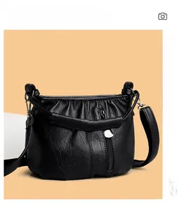 Detail of black pleated cloud bag texture with soft PU leather and metallic hardware