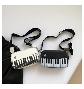 Detail view of mini crossbody bag featuring a piano keyboard print and music logo