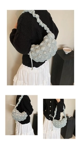 Detail of light blue pleated puffy cloud bag with textured quilted fabric and elastic strap