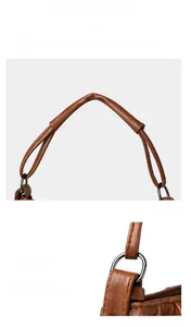 Detail of reinforced cylindrical handle on brown lychee grain leather handbag