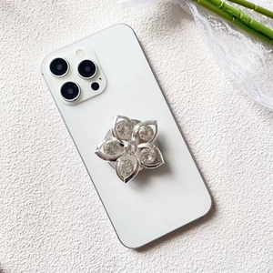 Close-up of luxury flower-shaped phone socket with sparkling crystals on white phone
