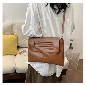 Brown retro leather shoulder bag shown in a lifestyle setting with a soft interior background