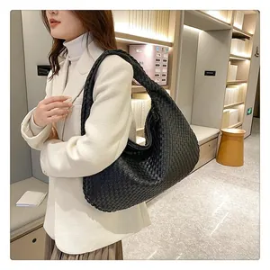 Dettaglio macro della borsa hobo in pelle intrecciata nera che mostra la trama e la capacità