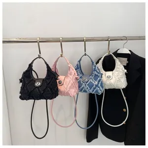 Quilted denim crescent bags with fringe detail in black, pink, blue, and cream colors