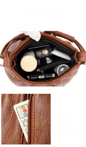 Macro view of brown faux leather handbag showing multi-compartment interior and storage space