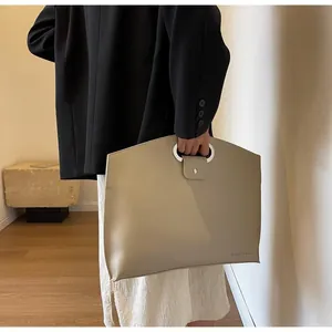 Detail of khaki tote bag with metal ring handle and Originally text on the side