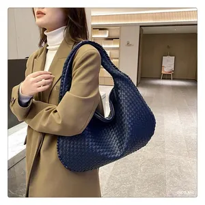 Dettaglio della borsa hobo intrecciata blu scuro con ampia capacità e trama in pelle