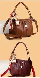 Detail of luxury pleated leather handbags with silk scarf and silver zipper accents