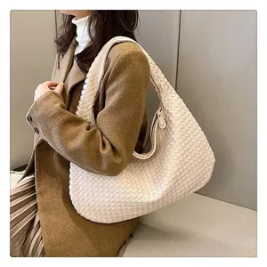 Grande borsa hobo beige in pelle intrecciata abbinata a un blazer marrone di classe