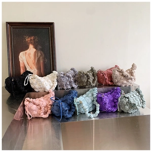 Close-up of quilted cloud bags with ruffled handles in multiple vibrant colors on display